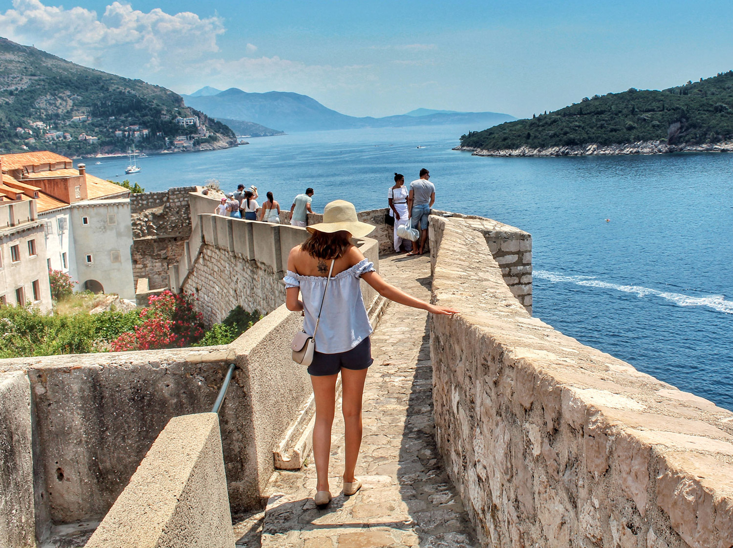 Woman walking along castle wall in Dubrovnik
