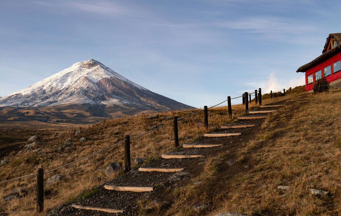 Step leading to a red building infront of Cotopaxi volcano