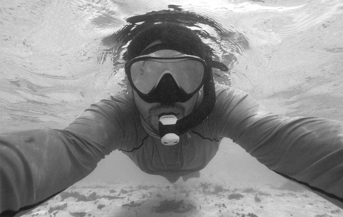Person snorkeling underwater in black and white
