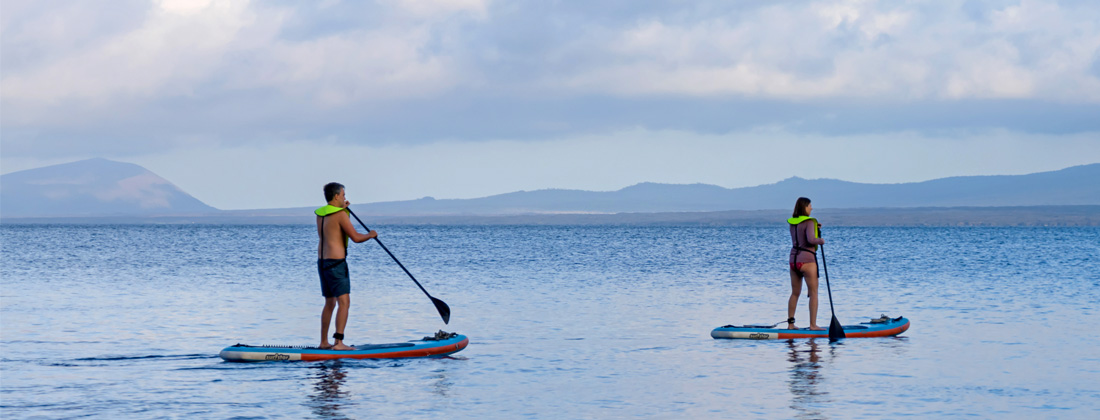 Man-and-woman-on-standup-paddleboards-on-blue-sea Man and woman on standup paddleboards on blue sea